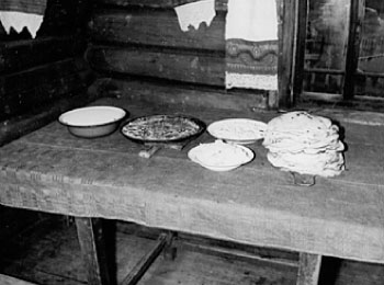 Накрытый стол: блины (табань), селянка (сулэтэм), топленое масло (шунтэм вой), заквашенное молоко (йолныд), селянка с рыбой (чорыг селянка). Кадр из фильма. 1987 г. УАССР, Глазовский р-н, д.Озегвай.